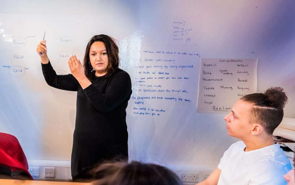 Psychotherapist and Counsellor is stood at a white board explaining an exercise to a MacsMAD trainee