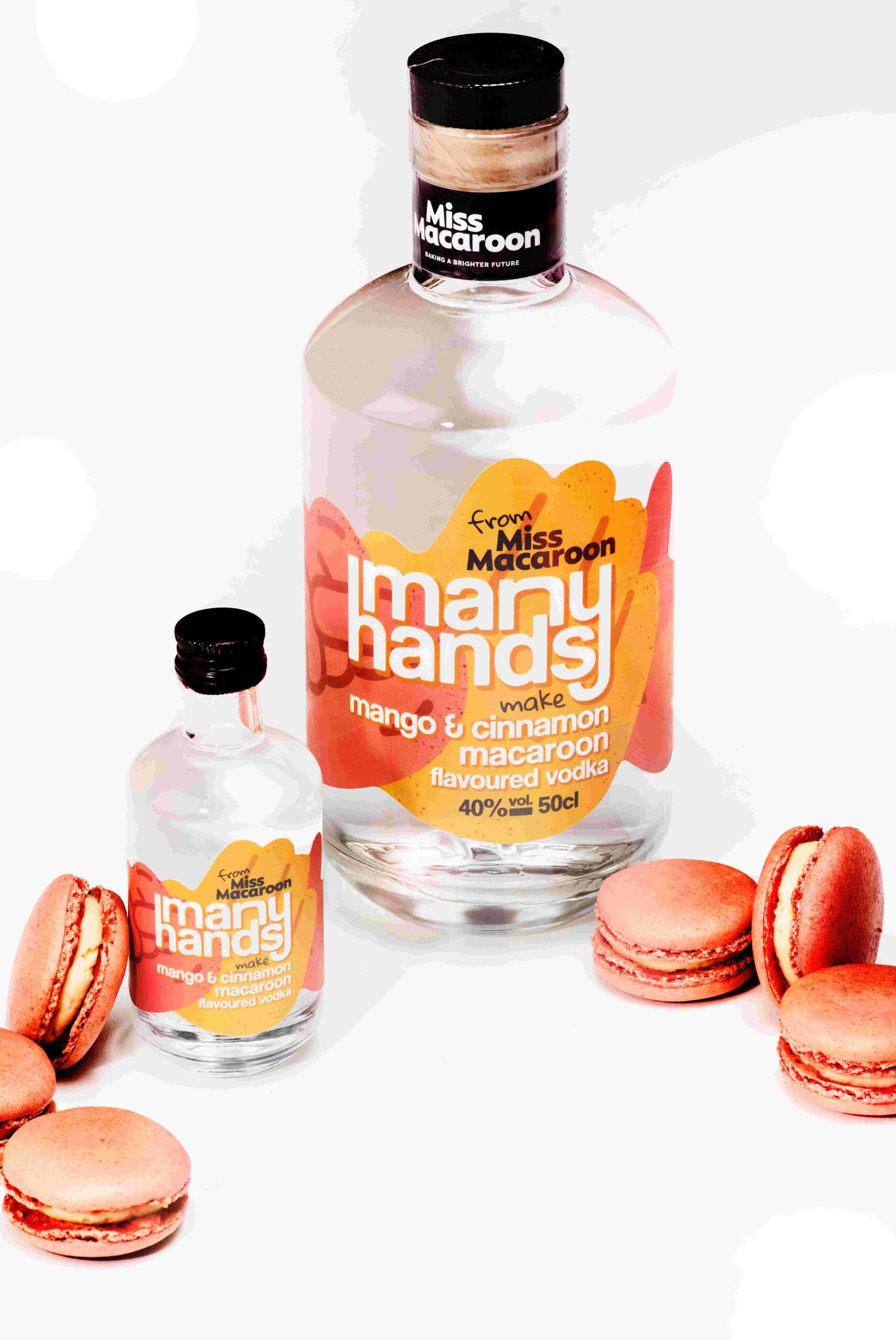 500ml and 50ml bottles of Many Hands Make mango & cinnamon macaroon flavoured vodka. Yellow and orange label. With mango and cinnamon macaroons