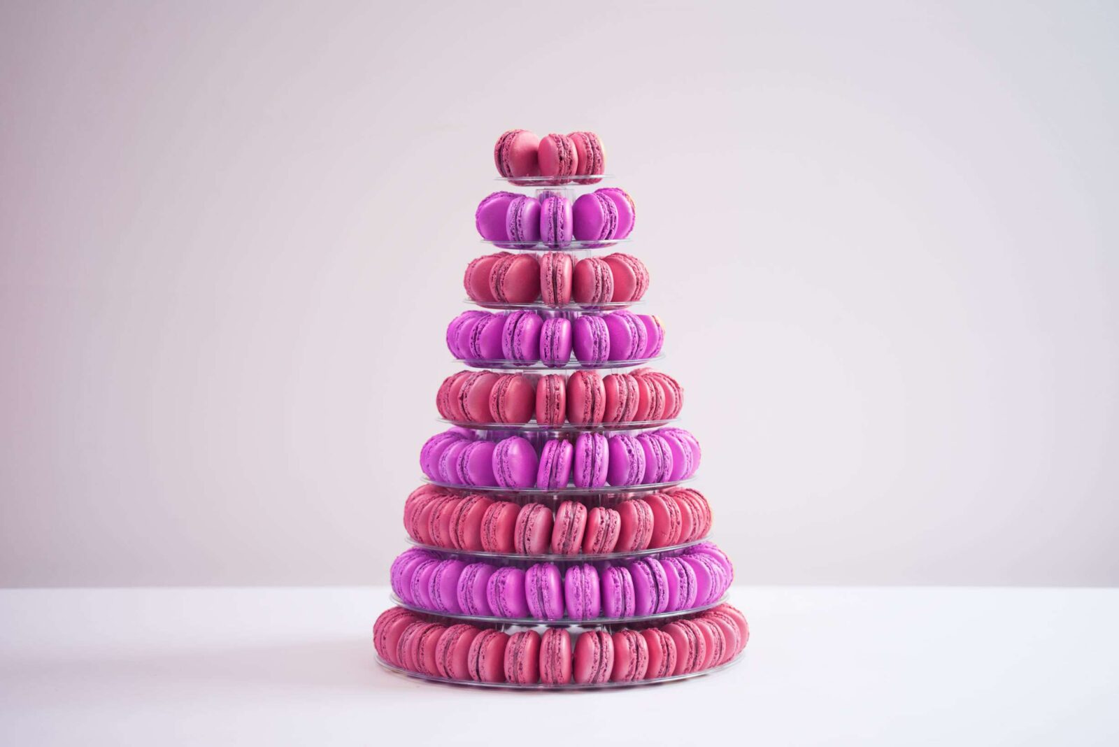 Nine tier conical tower containing 210 macaroons in purple and deep pink.