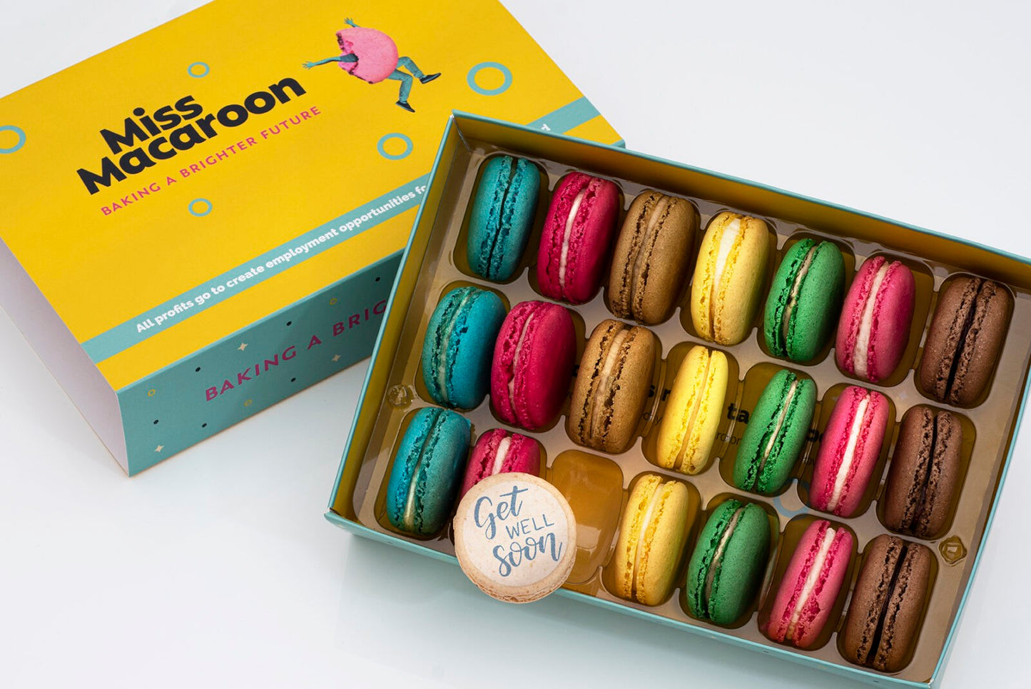 Gift box of 21 macaroons. Three of each flavour, seven different bright coloured macaroons, with one cream macaroons printed with decorate words 'Get well soon'.