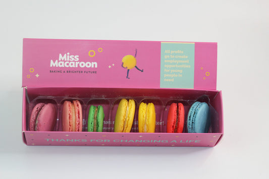 A Dairy-free pink macaroon box with 7 multi coloured macaroons on display