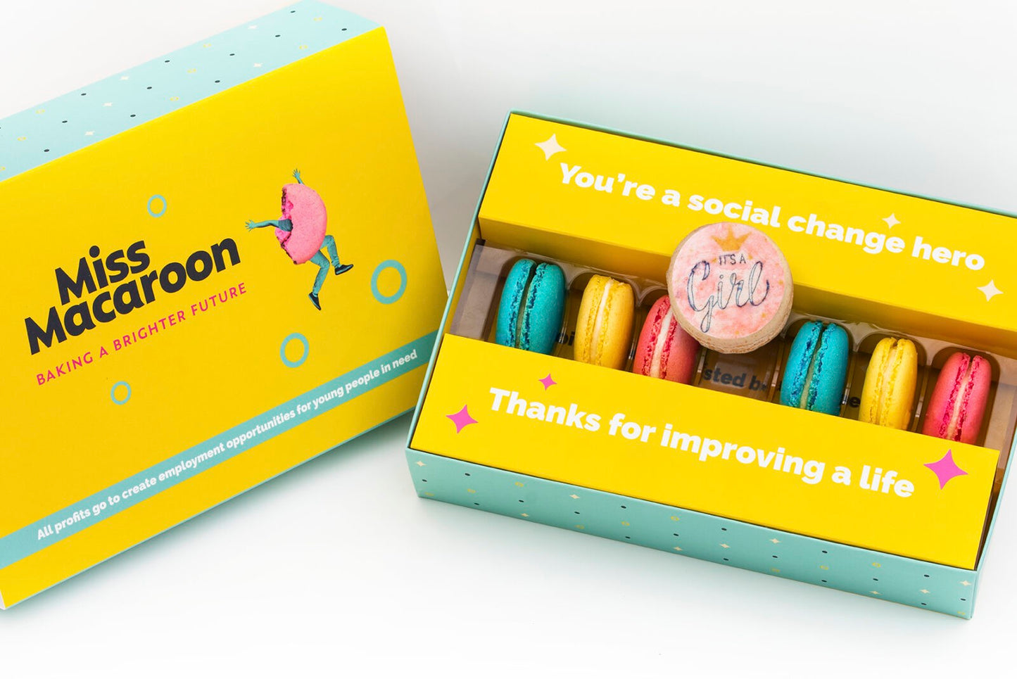 Gift box of 7 pink, yellow, cream and blue macaroons, with one printed with an 'it's a girl logo' with crown motif on.