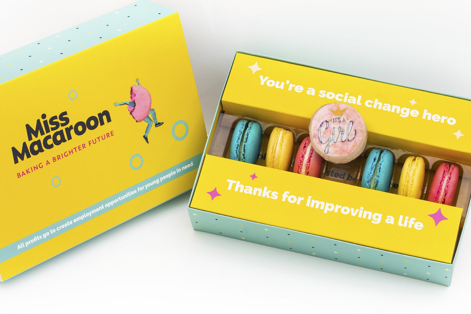 Gift box of 7 pink, yellow, cream and blue macaroons, with one printed with an 'it's a girl logo' with crown motif on.