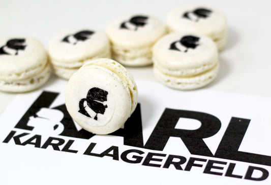 Branded Macaroon displayed for Karl Lagerfeld. There are six macaroons with thet logo of Karl Lagerfeld. Five logos are lying down while one stands on the logo of Karl Lagerfeld