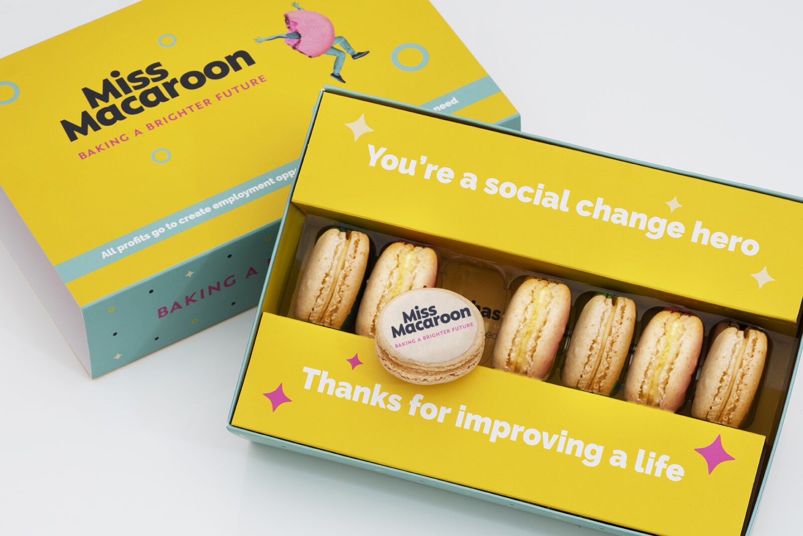 Yellow gift box of seven cream macaroons printed with a company logo.