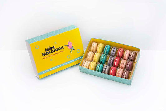 A yellow box of macaroon displaying 6 different coloured macaroons each represented by 3 macaroons