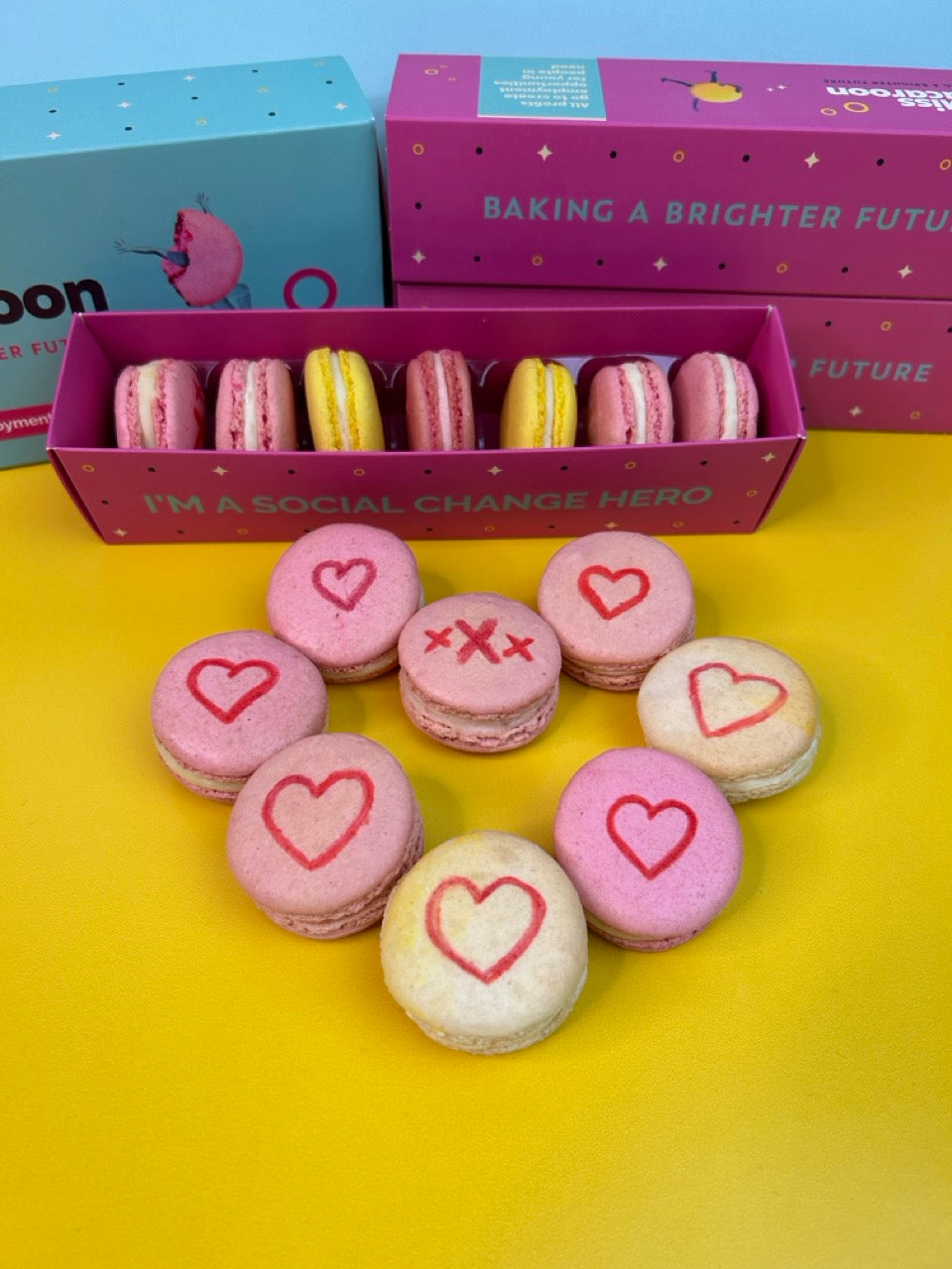 Natural raspberry and lemon macaroons with hand painted hearts on