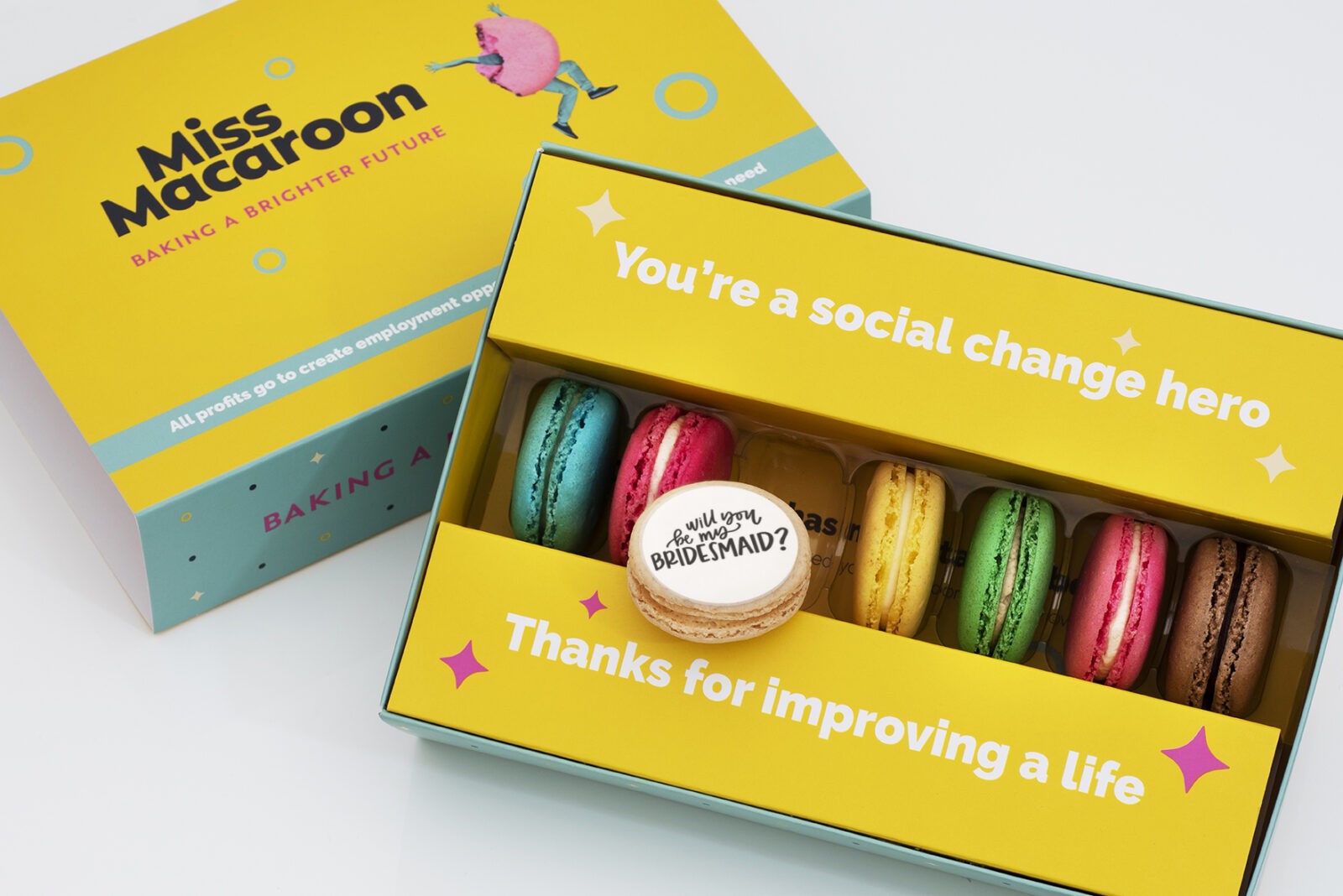 Gift box of seven macaroons. One of each flavour, seven different bright coloured macaroons, with "Will you be my Bridesmaid?" picture printed on.