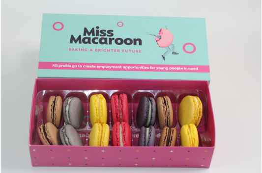 A blue box displayed with 14 macaroons with 7 different colours kept together in pairs